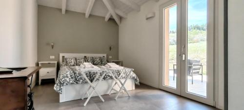 a bedroom with a bed and a large window at Colle Gelso in Cesena