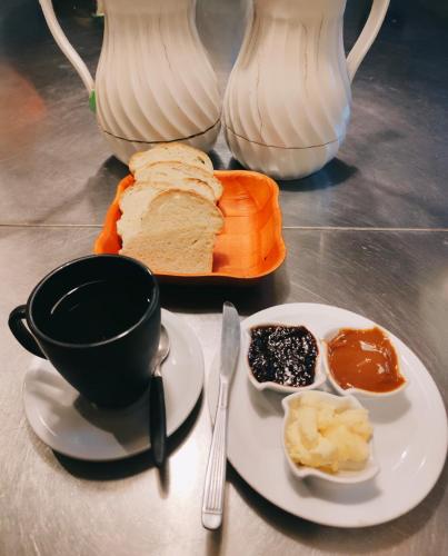 Una mesa con un plato de pan y una taza de café. en Hebes House Hostal, en Caviahue