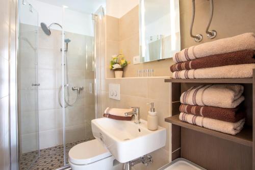 a bathroom with a sink and a shower and towels at Dream Apartment Rijeka 3 in Rijeka