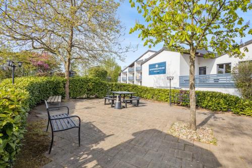 a park with benches and a table in front of a building at Sali Homes - Monteurwohnung Kevelaer in Kevelaer