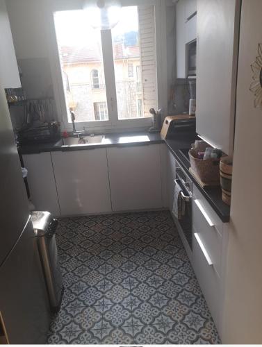 une petite cuisine avec un évier et une fenêtre dans l'établissement Idéale pour vos vacances 3 pièces avec terrasse et stationnement, à Nice