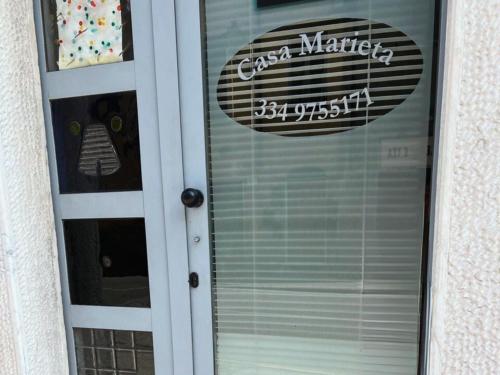 a glass door with a sign on top of it at Marieta Rooms in Sarzana