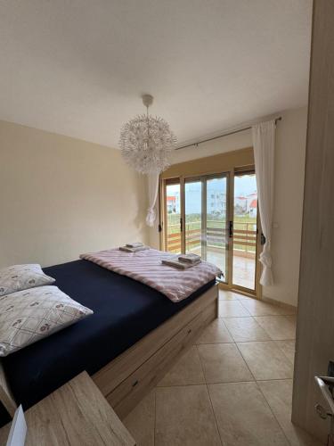 a bedroom with a large bed and a chandelier at Vesanos Mezonet in Toroni