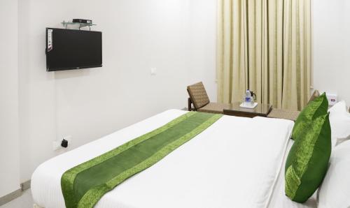 a bedroom with a bed with a tv on the wall at Hotel Kamron Near Airport Road Sector 78 Mohali Chandigarh in Mohali