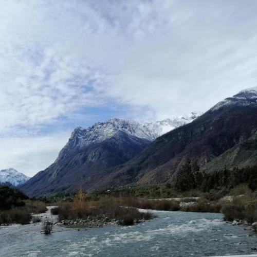 a river with snow capped mountains in the background at Refugio OHANA in Linares