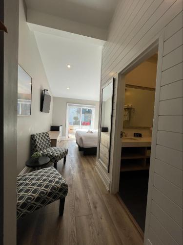 a room with a bedroom with a bed and a mirror at Colonial Hotel & Suites in Grand Bend