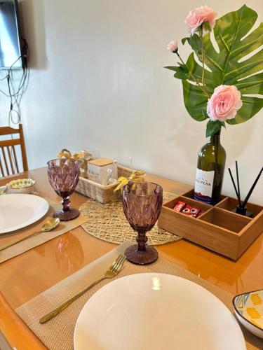 a table with a white plate and a vase with flowers at Centrio Tower Cozy 1 Bedroom with City View in Cagayan de Oro
