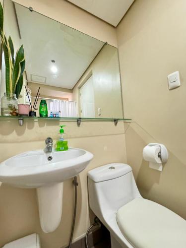a bathroom with a sink and a toilet and a mirror at Centrio Tower Cozy 1 Bedroom with City View in Cagayan de Oro