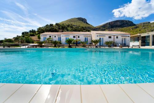 a swimming pool in front of a villa at Hotel Antica Cascina Del Golfo in Scopello
