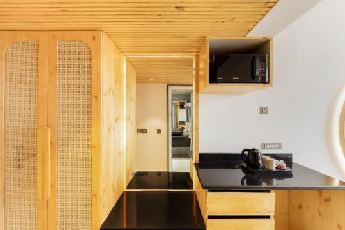 a kitchen with a black counter top and a microwave at Kyomi Retreat-Mukteshwar in Mukteswar