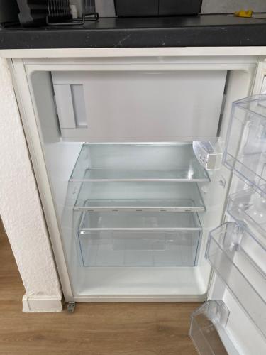 einem leeren Kühlschrank mit offener Tür in der Küche in der Unterkunft Apartment zentral in Gießen mit Balkon! in Gießen