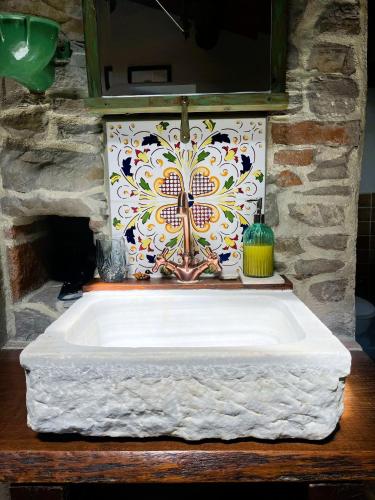 a bathroom sink with a colorful tile on the wall at Monte Paradiso Agriturismo in Pietralunga