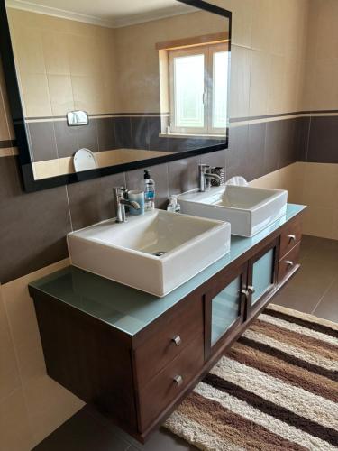 a bathroom with two sinks and a large mirror at Villa Quinta Dom Reis in Batalha