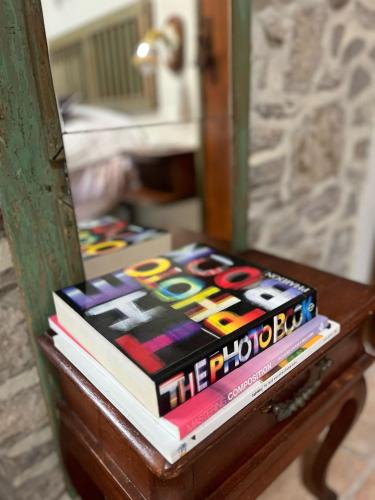 a pile of books on a table in front of a mirror at Monte Paradiso Agriturismo in Pietralunga