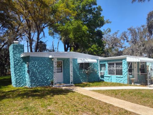 a blue house in a park with trees in the background at Spring Street Retreat in St. Augustine