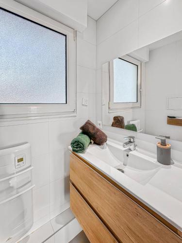 une salle de bain blanche avec un lavabo et une fenêtre dans l'établissement L'Amphitrite 1 Stella vue mer, à Cucq