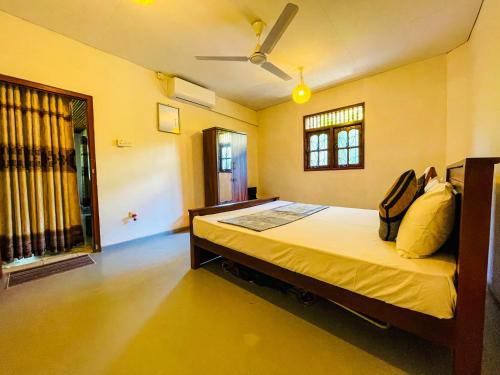1 dormitorio con 1 cama con paredes amarillas y techo en Obawatta Villa Unawatuna, en Unawatuna