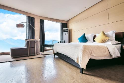 a bedroom with a large bed and a large window at Dali Shuanglang seven-room sea view hotel in Dali Shuanglang