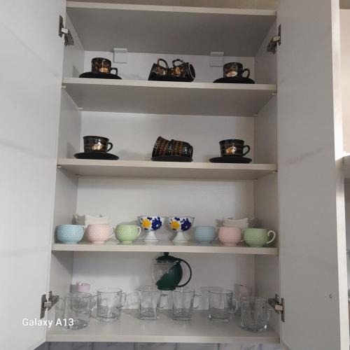 a shelf with cups and vases on it at Nugzar House Chakvi - 2 Bedrooms in Chakvi