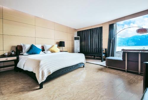 a bedroom with a large bed and a large window at Dali Shuanglang seven-room sea view hotel in Dali Shuanglang