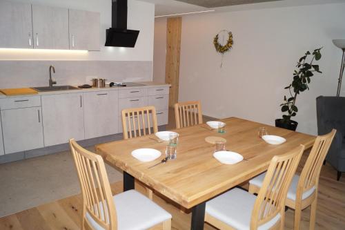 a dining room table with chairs and a kitchen at Laimbruchhof Apartments Urlaub auf dem Bauernhof in Val di Vizze