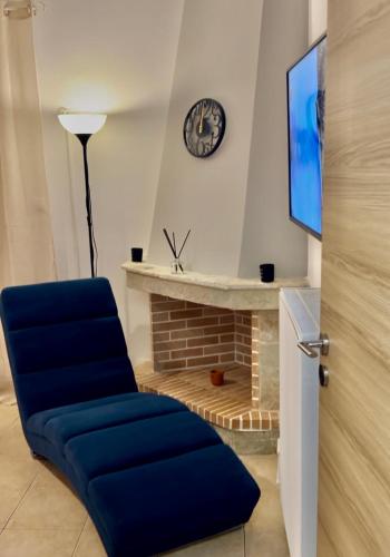 a living room with a blue chair and a fireplace at Costa Kalamos Suites in Kalamos