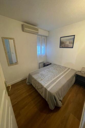 une chambre avec un lit dans une pièce blanche dans l'établissement Magnifique T2 - Émeraude 41, à Canet