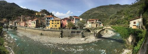 an old bridge over a river in a town at CA DE MIN Haut de Villa à Badalucco in Badalucco