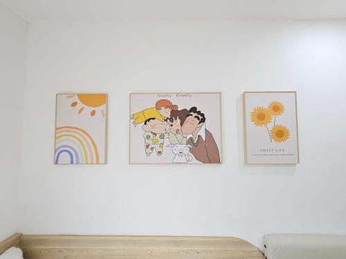 three illustrations of a family hanging on a wall at 舞浪海景旅店 in Xiaoliuqiu
