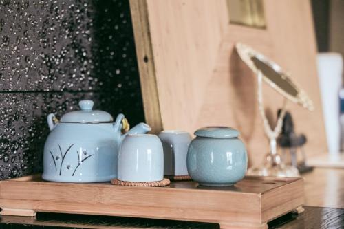 a group of blue vases sitting on a wooden shelf at Dali Shuanglang seven-room sea view hotel in Dali Shuanglang