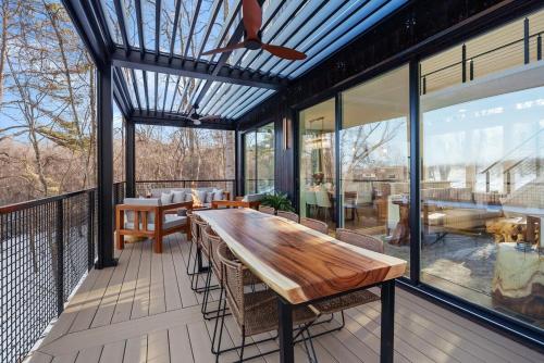a screened in porch with a wooden table and chairs at Adamina Canyon Luxurious, Canyon View 5BR, 3BTH 1 in Rockbridge