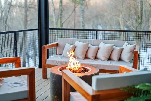 a couch sitting on a deck with a fire pit at Adamina Canyon Luxurious, Canyon View 5BR, 3BTH 1 in Rockbridge