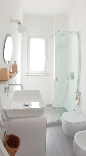a white bathroom with a sink and a shower at La Pica Marina Anacapri in Anacapri