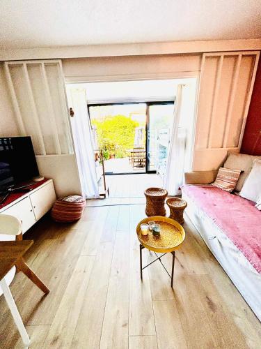 un salon avec un lit et une table dans l'établissement La petite Pinède Studio climatisé proche plage, à Sanary-sur-Mer
