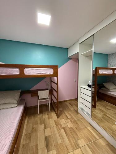 a room with two bunk beds and a mirror at Casa completa e confortável, 15 minutos dá praia in Maceió
