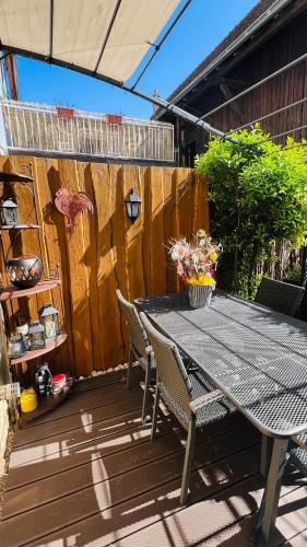 a patio table and chairs on a wooden deck at GITE LE COQ ROUGE in Eguisheim