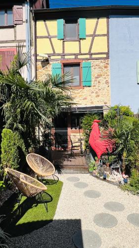 a patio with two chairs and a building at GITE LE COQ ROUGE in Eguisheim