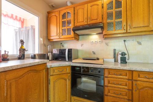 a kitchen with wooden cabinets and a stove top oven at MagicLoc in Esbly