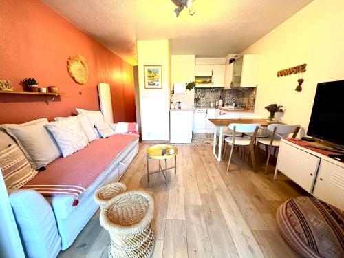 un salon avec un canapé et une cuisine dans l'établissement La petite Pinède Studio climatisé proche plage, à Sanary-sur-Mer