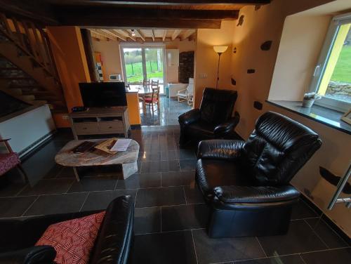 a living room with leather chairs and a coffee table at La Catiche in Bastogne