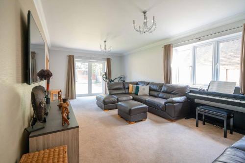 a living room with a couch and a piano at Peaceful Double Room in Bromley