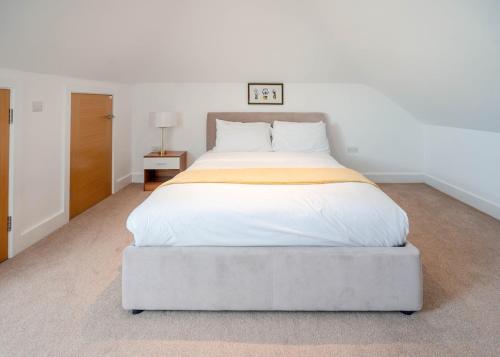 a bedroom with a large bed with white sheets at Peaceful Double Room in Bromley
