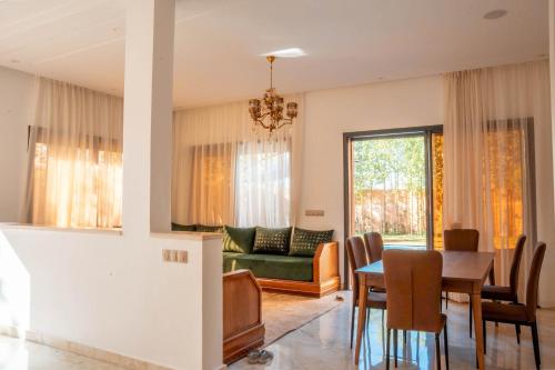 a living room with a table and a couch at Villa Park Marrakech in El Aggada