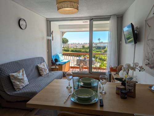 un salon avec une table et un canapé dans l'établissement Sol-y-Days Canastel, Studio avec coin couchage, quartier du Boucanet proche commerces et plage, au Grau-du-Roi