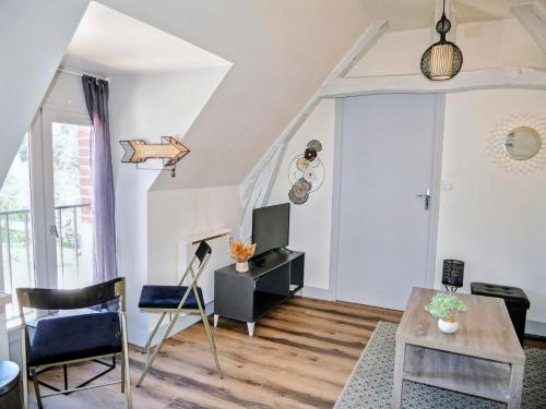 un salon avec une table et une télévision dans l'établissement Tranquillité, Parking, Proche Châteaux de la Loire, à Saint-Gervais-la-Forêt