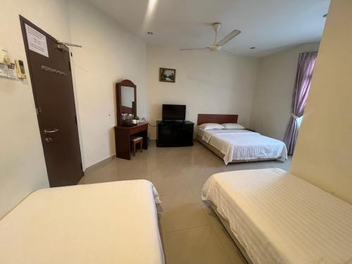 a hotel room with two beds and a mirror at Hotel O Kledang Menglembu in Ipoh