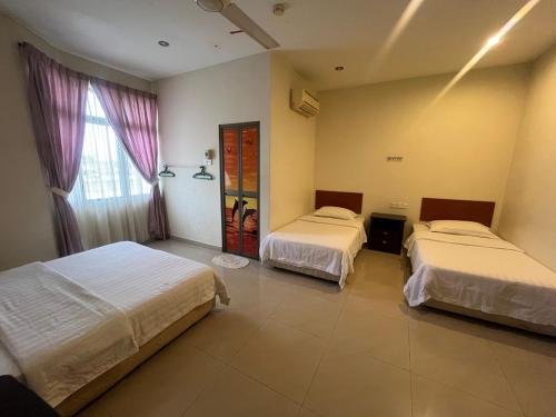 a hotel room with two beds and a window at Hotel O Kledang Menglembu in Ipoh