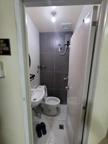 a bathroom with a toilet and a sink at BenRitz Transient House in Urdaneta