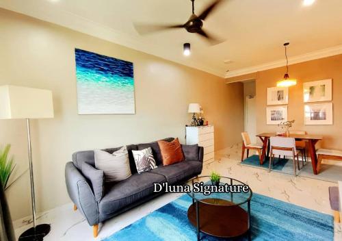 una sala de estar con un sofá y una mesa en D'luna Homestay Terengganu SEA VIEW / DRAWBRIGE VIEW / NEAR HSNZ, KTCC, DRAWBRIGE, en Kuala Terengganu