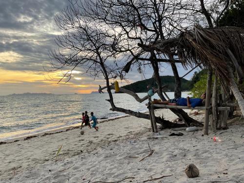 a man laying on a bench on a beach at Beachfront Tiny House, Koh Samui, Thailand with FREE Rowboat in Amphoe Koh Samui